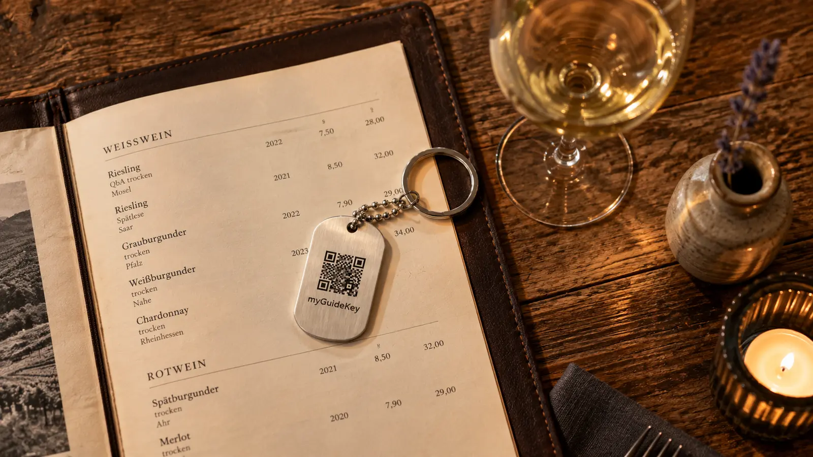 Der Anhänger liegt auf einer Weinkarte neben einem Glas Weißwein